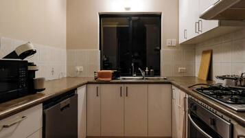A kitchen with a microwave, stove, sink, and cabinets.