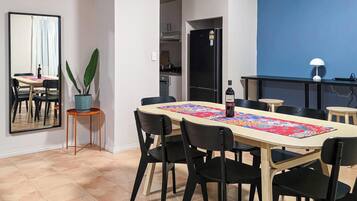 A dining area with a long table, black chairs, and a colorful table runner.