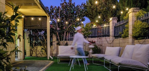 An outdoor patio area with a seating arrangement and string lights. - 3 BR Urban Retreat w/ Private Garden - Work Ready near CBD, Beach, Golfs & Malls (Nollamara)