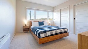 A bedroom with a bed, bedside tables, a window, and a door. - Derwent Outlook Gateway to Scenic Trails and Beaches (Mount Nelson)