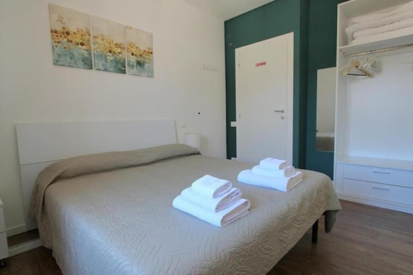 A hotel room with a bed, a wardrobe, and a door. - A Casa di Alice (Tavullia)