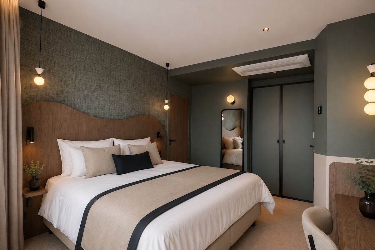 A modern hotel room with a large bed, bedside tables, a desk, and a chair.