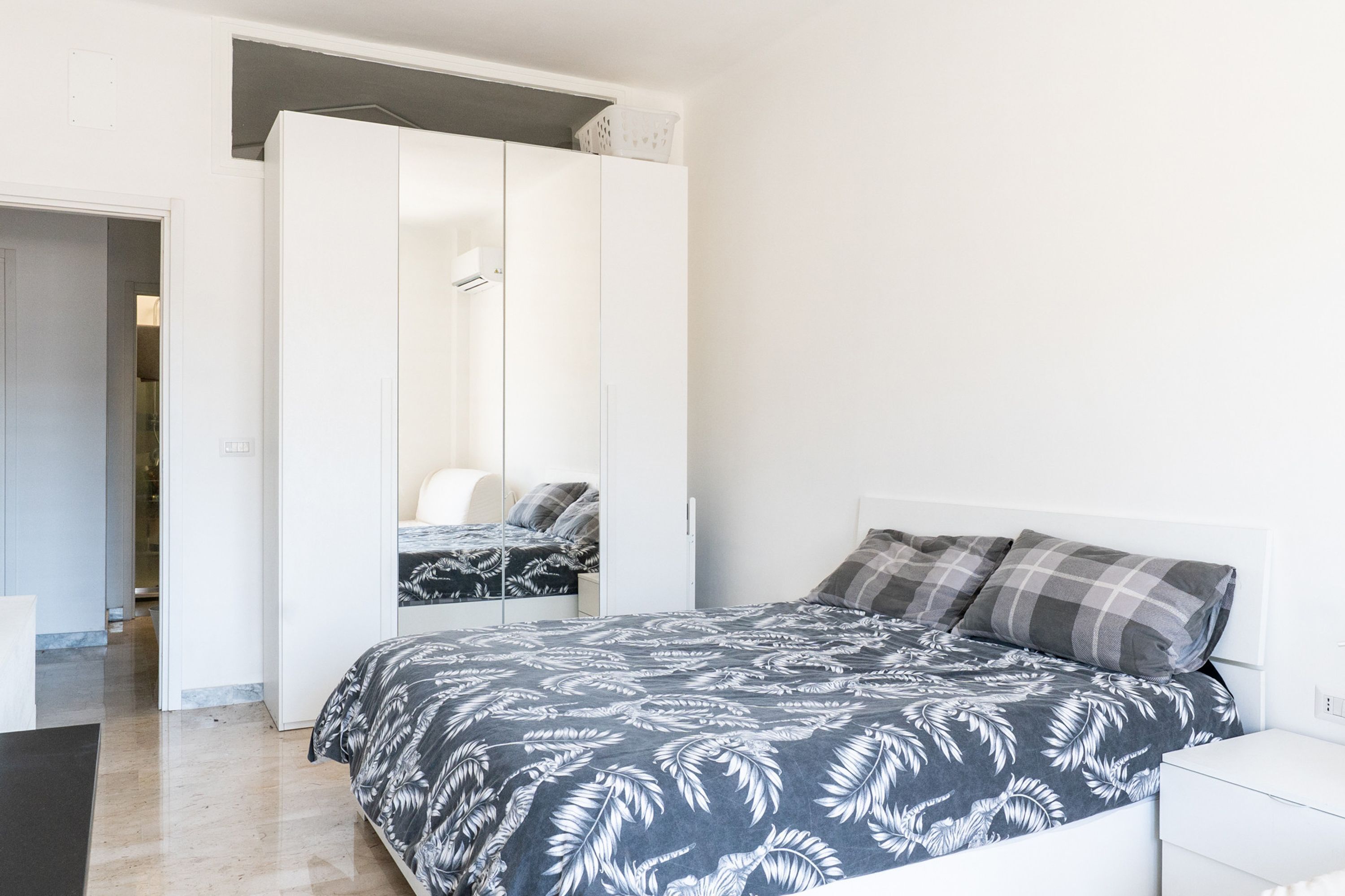 A bedroom with a bed, a wardrobe, and a desk.