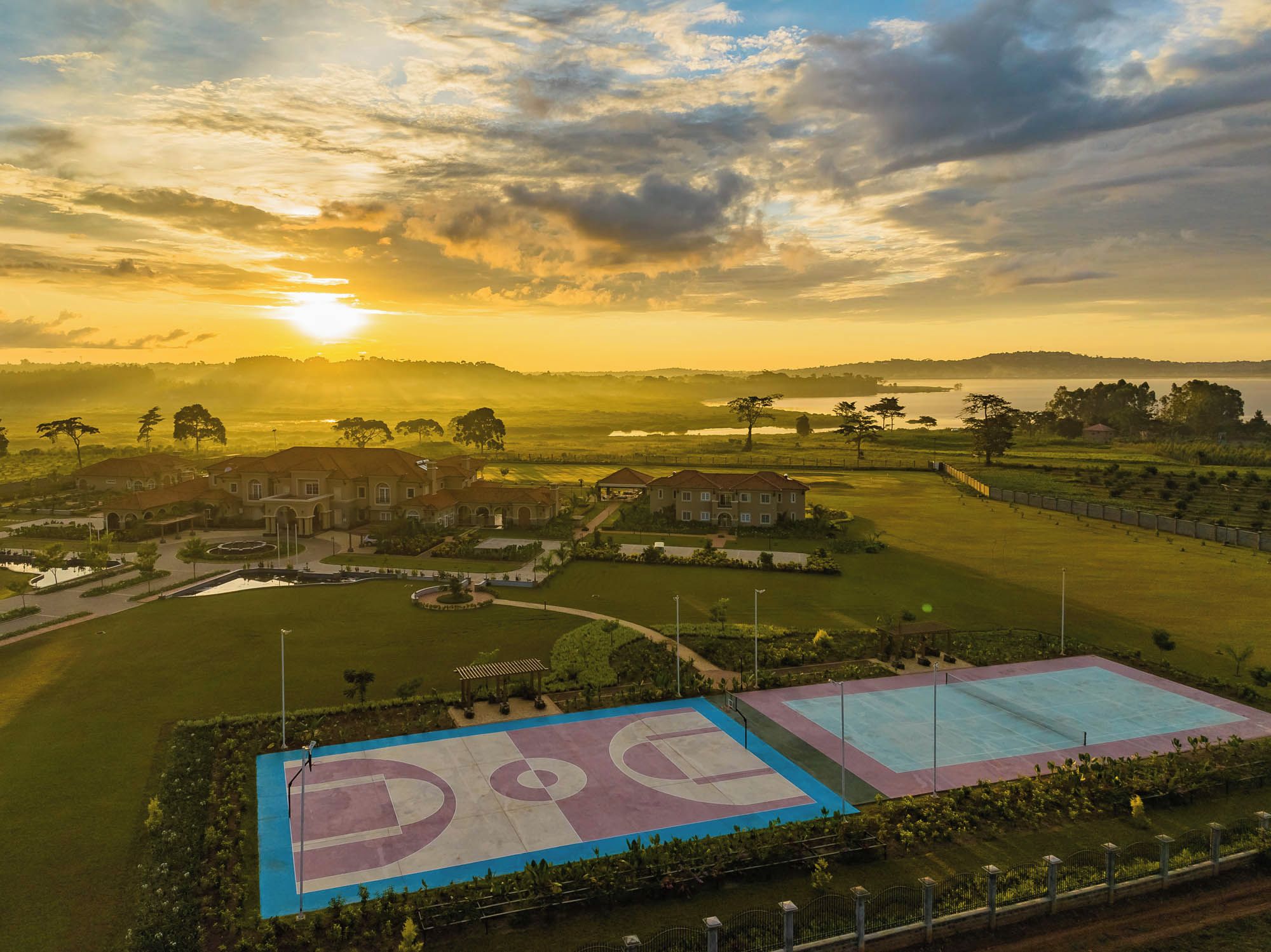 A residential area with houses, a basketball court, and a large body of water.
