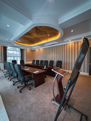 A conference room with a long table, multiple chairs, and a unique ceiling design. - Avellino Lakeside Escape (Entebbe)