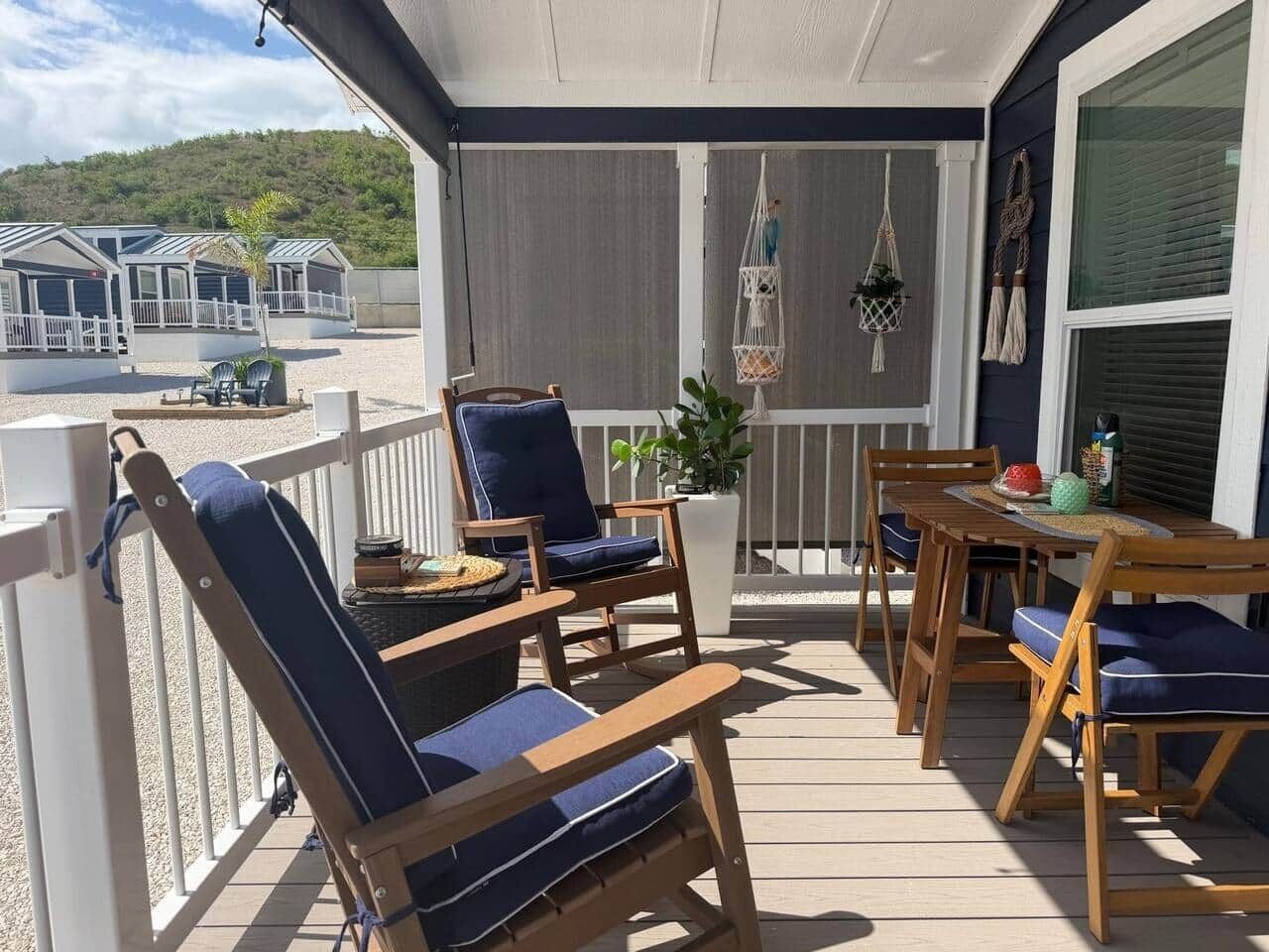 A covered outdoor seating area with wooden furniture and a potted plant.