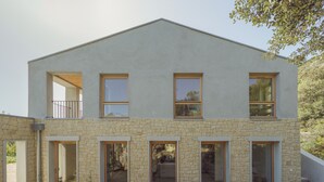 A modern two-story building with large windows, stone facade, and a balcony. - A quiet home, between Provence and the Calanques (Simiane-Collongue)