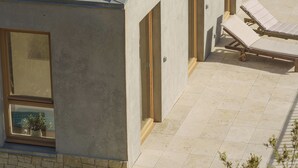 A modern building with a tiled roof, a balcony with sun loungers, and a stone wall. - A quiet home, between Provence and the Calanques (Simiane-Collongue)