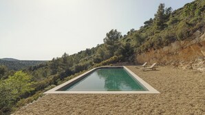 A rectangular pool with a pebble deck, two lounge chairs, and a mountainous backdrop. - A quiet home, between Provence and the Calanques (Simiane-Collongue)