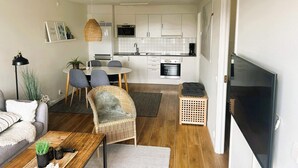 A modern apartment with a dining area, kitchen, living room, and a TV. - 5 Star Holiday Home in Uddevalla (Uddevalla)