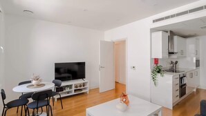 A modern living room with a dining area, a TV, and a kitchen. - 3-bed Flat Near Oxford Circus Sleeps 6 AC (London)