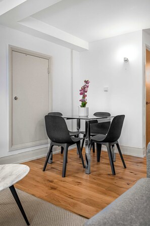 Een eethoek met een tafel, stoelen en een potplant.