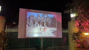 A projection of an ancient structure with arches and ruins, displayed on a screen.