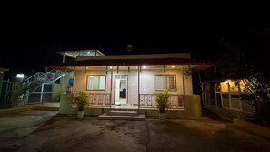 A two-story building with a staircase on the left, a balcony on the right, and a door in the center. - Cozy 1-bedroom farmhouse in serene Badlapur with AC (Badlapur)