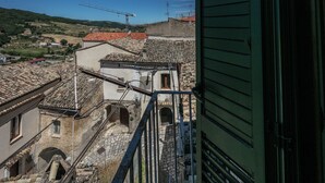 Blick auf eine traditionelle Stadt mit Steinhäusern, einer sichtbaren Treppe und einem Kran in der Ferne.