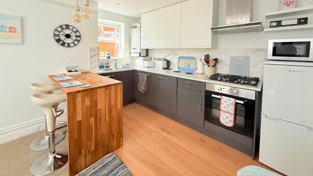Eine moderne Küche mit einer Holztheke, Edelstahlgeräten und Blick ins Freie.