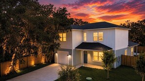 A two-story house with a garage, a well-maintained lawn, and a wooden fence. - Private Pool • Walk to St. Augustine Beach (St. Augustine)