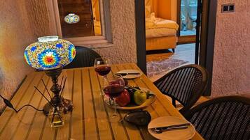 Una mesa de comedor con una lámpara decorativa, platos, cubiertos y un frutero.