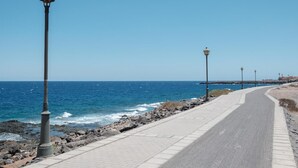 A coastal road with street lamps, a paved walkway, and the ocean in the background. - Sunny Apartment in Costa de Antigua for 4 Guests (Nuevo Horizonte)