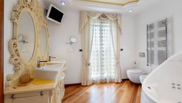Une salle de bain comprenant un meuble-lavabo, un lavabo, un miroir, des toilettes et une baignoire.
