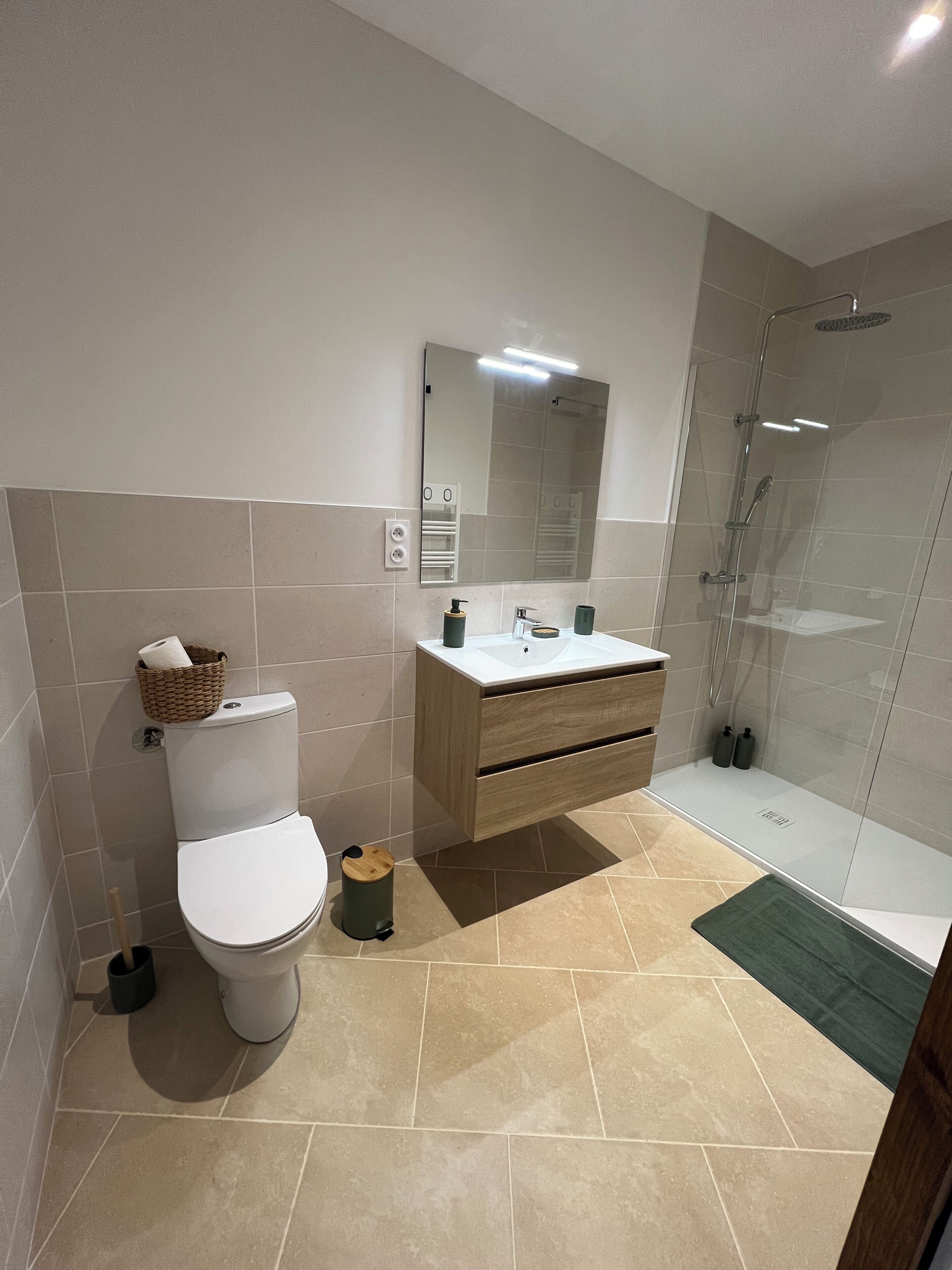 Un baño con inodoro, lavamanos, espejo y ducha.