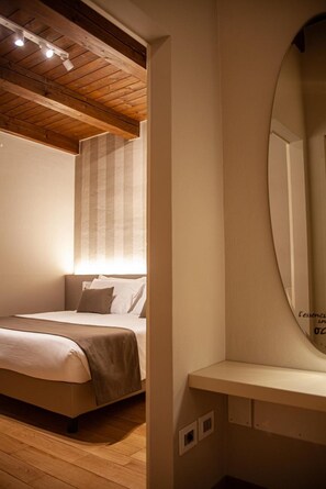 Un dormitorio con techo de madera, una cama con cabecera, una mesita de noche y un espejo.
