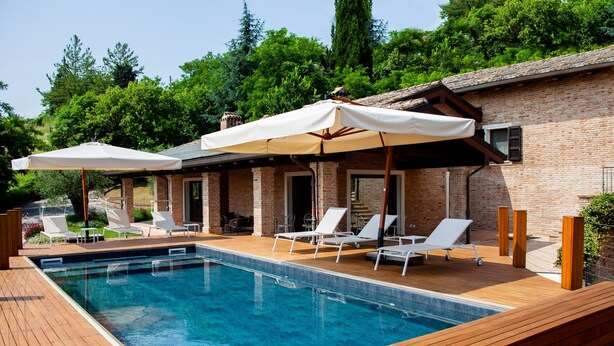 A swimming pool with wooden deck, white lounge chairs, and umbrellas. - Room 'Resort Villa Paola - Camera Tordo' with Sea View, Wi-Fi and Air Conditioning (Longiano)