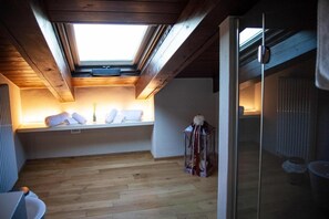 A room with a skylight, wooden beams, a white bench with towels, and a glass door. - Resort Villa Paola – Falco Room with Sea View, Wi-Fi and Air Conditioning (Longiano)