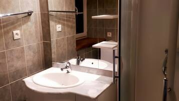 A modern bathroom with a sink, mirror, and shower.