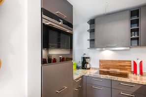 A modern kitchen with stainless steel appliances, a built-in oven, and a coffee maker.