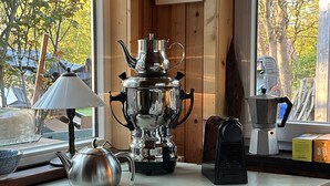 Un comptoir de cuisine avec une machine à café, une bouilloire et une lampe.
