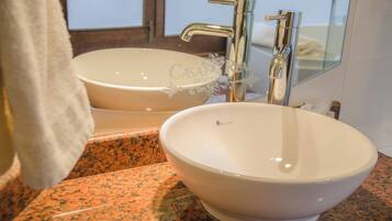 A bathroom with two sinks, a mirror, and a towel hanging on the wall.