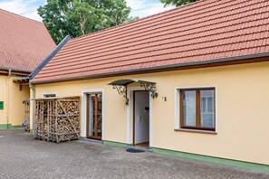 A building with a tiled roof, a wooden door, and a window.