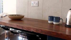 A kitchen with a dishwasher, a kettle, and a shelf with mugs. - Abbotscot near Bantham, S. Devon (West Buckland, Bantham)