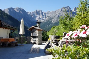 A stone-built outdoor seating area with a view of mountains. - Apartment 'Agriturismo Grones' with Mountain View, Shared Terrace and Wi-Fi (San Martin de Tor)