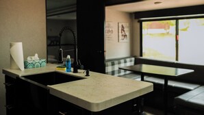 Una cocina con un lavamanos, una grifería, una encimera y una ventana con vistas al exterior.