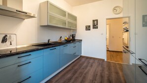 Een moderne keuken met blauwe kastjes, een roestvrijstalen spoelbak en een inbouwoven.