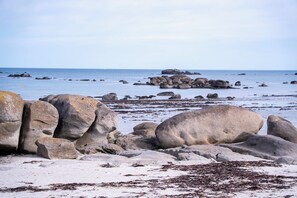 A rocky shoreline with large boulders and seaweed. - Villa Josée – Renovated family home, 700 meters from the beach (Kerlouan)