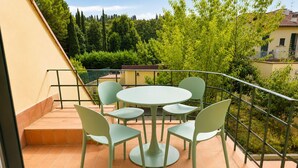 A terrace with a round table and four chairs, surrounded by a metal railing. - Modern Terrace Retreat (Florence)