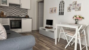 A modern kitchen with white cabinets, a tiled backsplash, and a built-in oven.