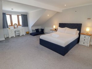 Ein Schlafzimmer mit Bett, Nachttischen, Schreibtisch und Stuhl.