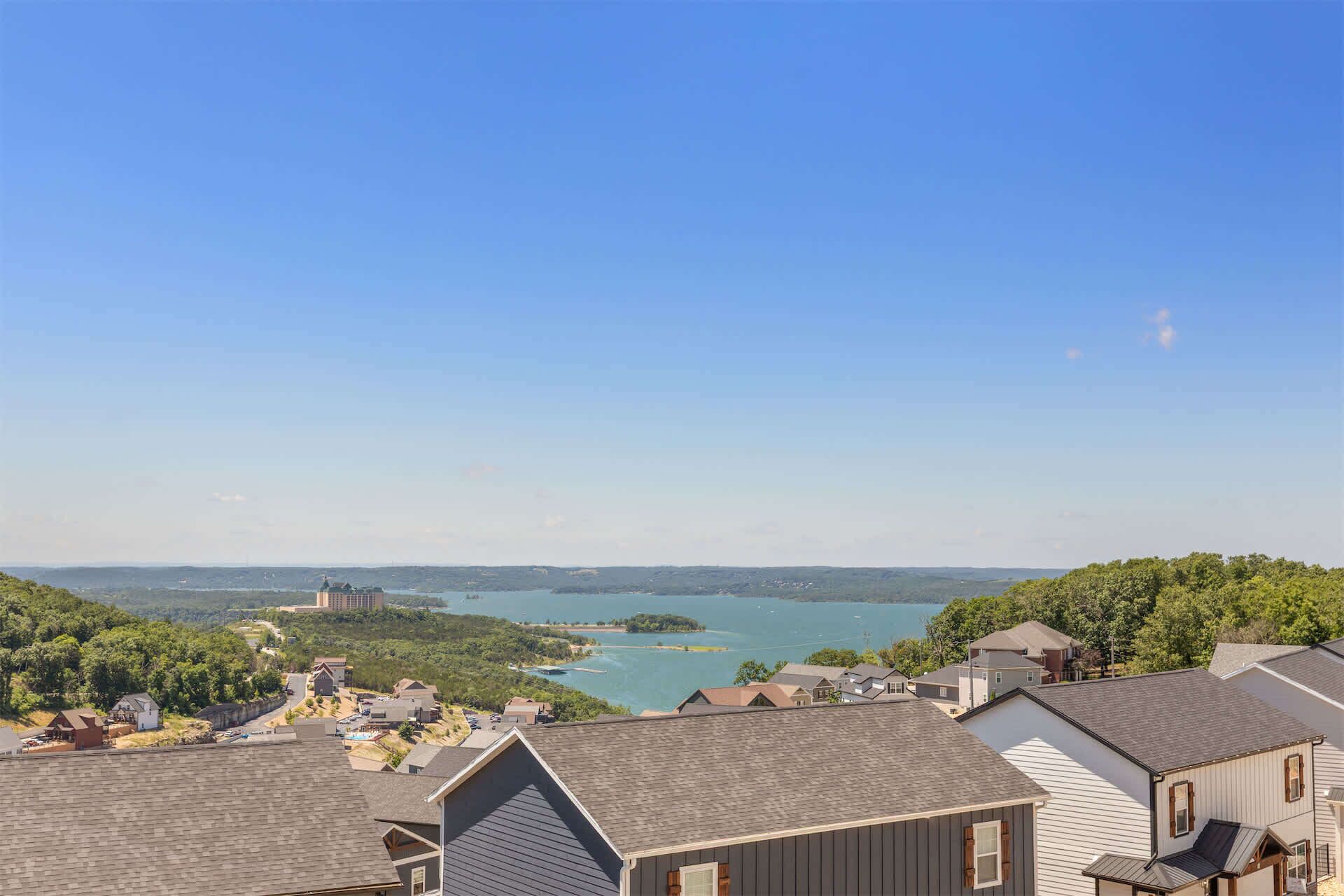 A residential area with houses, a large body of water, and a distant castle-like structure.