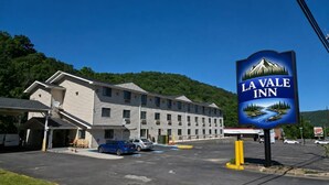 L’auberge La Vale, dotée d’un parking, présente un bâtiment avec de nombreuses fenêtres et une enseigne.