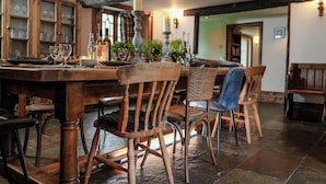 A rustic dining area with wooden furniture, a candle, and potted plants. - Bath House - Country Luxury on the Somerset Levels (Aller)