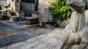 A stone statue in a courtyard with a stone building in the background. - Bath House - Country Luxury on the Somerset Levels (Aller)
