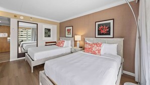 A hotel room with two beds, a bedside table with a lamp, a large mirror, and a door leading to a balcony. - @ Marbella Lane - Iconic Waikiki City View Getaway (Honolulu)