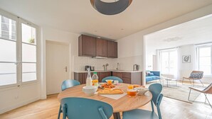 Una cocina moderna con alacenas de madera, una mesa de comedor con sillas y alimentos para el desayuno.