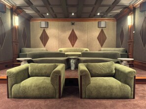 A room with a seating area featuring sofas and armchairs, a central table, and wall-mounted lamps. - Fauzan Country Club: A Private Residential Resort in Atlanta (Marietta)
