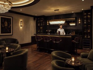 A bar area with a bartender, bar stools, and a chandelier. - Fauzan Country Club: A Private Residential Resort in Atlanta (Marietta)