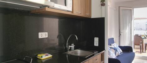 A kitchen with a microwave, sink, and stove.